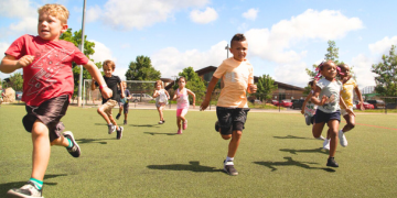 Kids running on a soccer field at a Salvation Army camp