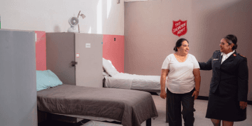 Salvation Army Officer walking with a woman in the dorm.