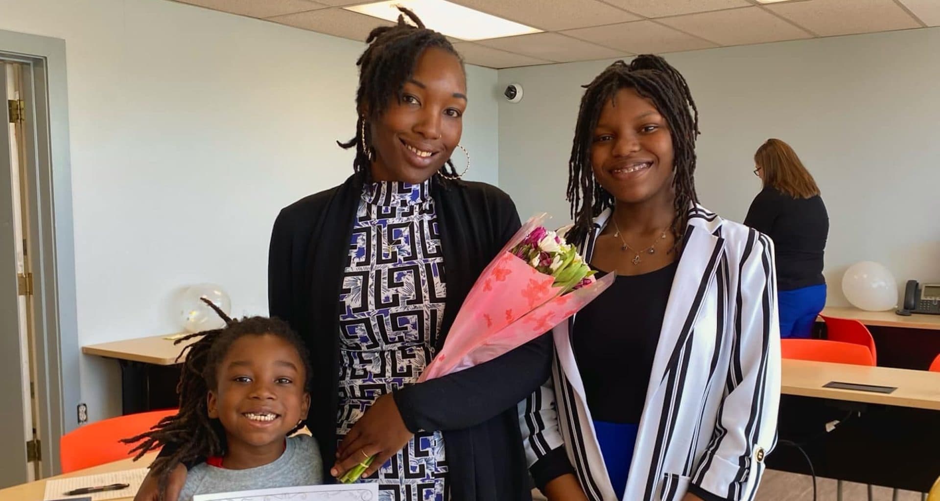 A mom holding a bouquet with her two daughters.